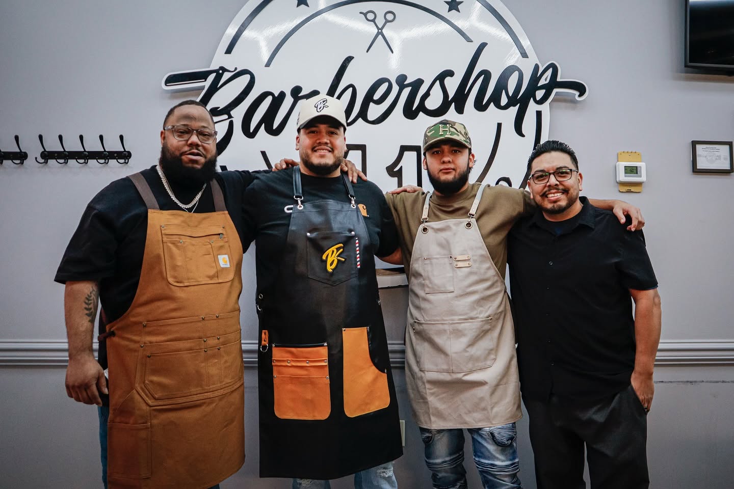 The four Barbershop 11 barbers standing together inside the shop